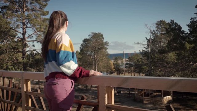 A girl on a terrace with forest view. Tourism