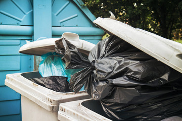 closeup of urban trash cans, plastic bags and different types of bins
