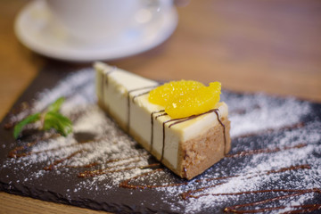 cheesecake on a black plate and coffee