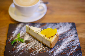 cheesecake on a black plate and coffee