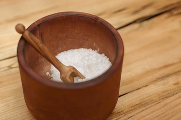 salt in a wooden plate with a wooden spoon