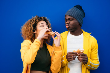 Young couple eating burger outdoors © karrastock
