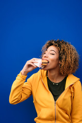 Young woman eating a burger on the street © karrastock