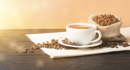 Cup of hot coffee with beans, close