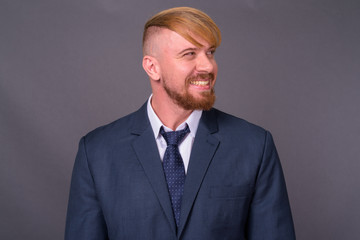 Bearded businessman with blond hair against gray background