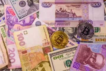 Bitcoin coins on the american, ukrainian and russian banknotes