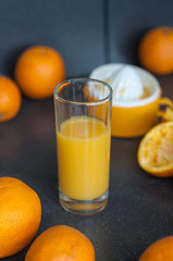 Oranges and juicer for making orange juice.. Black-gray background.