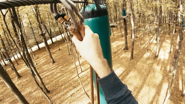 Person POV avoiding obstacles in adventure park course 4K. Camera on a person's head with a wide view while climbing in adventure park in autumn. Slow motion first person view.