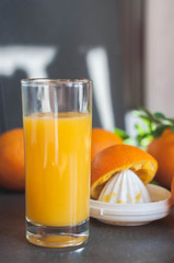 Oranges and juicer for making orange juice.. Black-gray background.