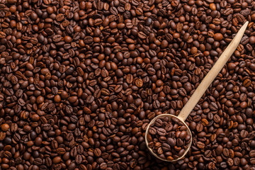 Wooden spoon with roasted coffee beans