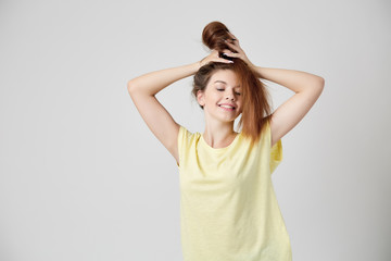 Fototapeta premium Girl in yellow t-shirt fooling around with her hair