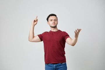 Thoughtful man in the burgundy t-shirt points his finger up