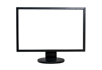 Computer monitor on a table against brick wall, blank white screen