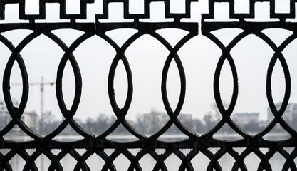 wrought iron grille on the bridge over the river of the blue city