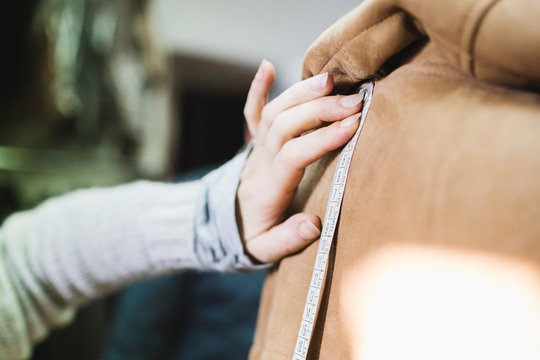 Seamstress takes the measurements of a leather jacket
