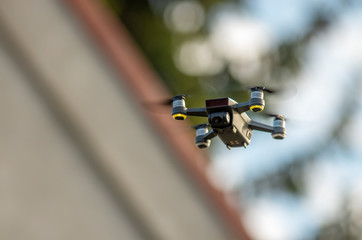 Dron podczas lotu, głębia ostrości, dom w tle.  © Aneta