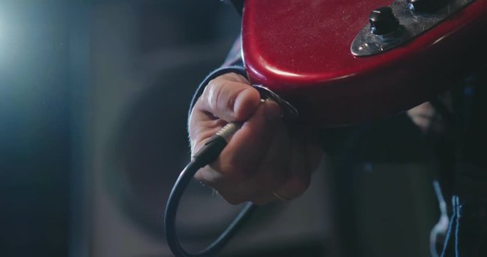 Close up of musician connecting guitar amp