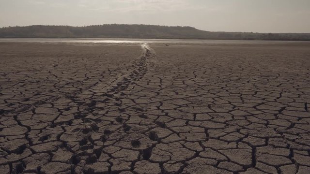 The bottom of the dried lake, traces of shoes on cracked soil