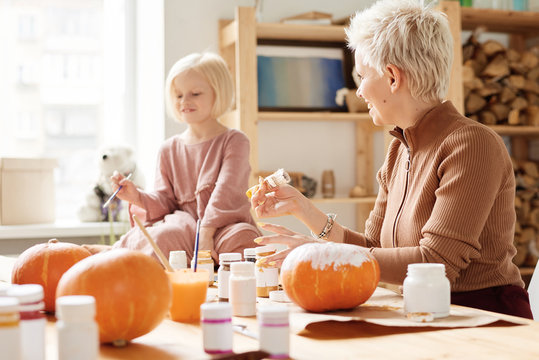 Cheerful family painting pumpkins