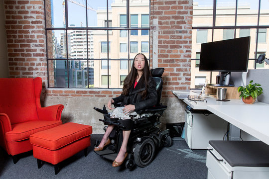 Woman with muscular dystrophy working in office