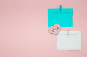 Photo frames with a heart on a blue and gently pink background. Love.