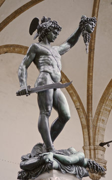 Firenze, Toscana, Italia, statua in bronzo del Perseo, di Benvenuto Cellini, collocata in piazza della Signoria, sotto la loggia dei Lanzi di cui sono visibili le arcate in pietra 