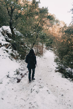Girl walking on her back on a snowy mountain trail