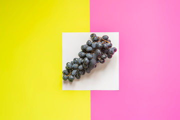 top view of flat lay of bunch of grapes on double color sirface background f
