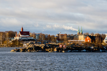 Tiny islands with historical buildings near the island Suomenlinna in Helsinki in Finland on a sunny winter day with snow.