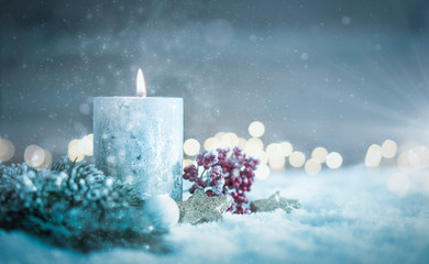 Winterliches Weihnachtsgesteck mit Kerze im Schnee