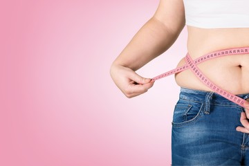 Close-up female figure with measuring tape on grey background