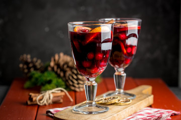 Christmas composition with spicy mulled wine and pine cones on red background