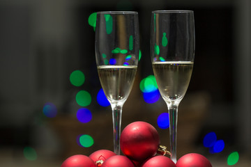 champagne glasses with balls and christmas lights