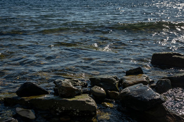 Obraz premium Sea stones and rocks of different sizes and texsture of black, gray and brown on the Black Sea coast as nature bacground. Excellent concept for any design