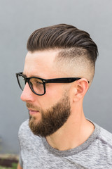 Side view of young bearded man isolated on gray background