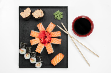 Obraz na płótnie Canvas close up of sashimi sushi set with chopsticks and soy on a serving tray