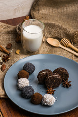 Candy and biscuit on a blue plate. Sweets on the fabric. A glass of milk