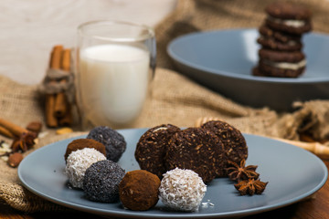 Candy and biscuit on a blue plate. Sweets on the fabric. A glass of milk
