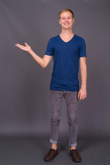 Portrait of young handsome man against gray background