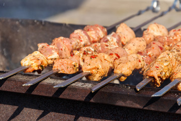 Grilled kebab cooking on metal skewer. Roasted meat cooked at barbecue