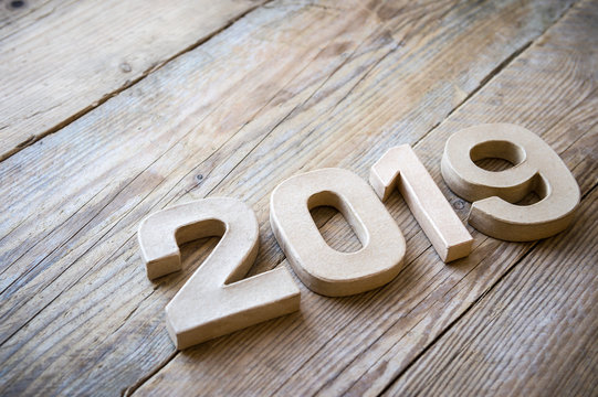 New Year 2019 message in plain brown cardboard numbers on natural weathered wood background