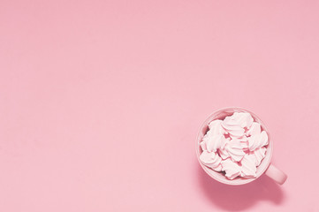 Cup with meringue on a pink background