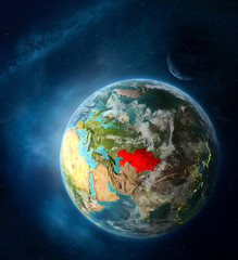 Kazakhstan from space on Earth surrounded by space with Moon and Milky Way. Detailed planet surface with city lights and clouds.