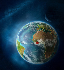 Obraz na płótnie Canvas Ivory Coast from space on Earth surrounded by space with Moon and Milky Way. Detailed planet surface with city lights and clouds.