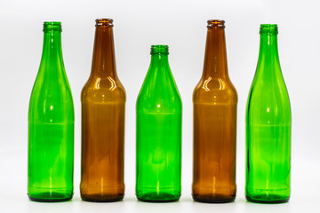 Colored empty glass bottles on white background