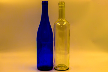 Colored empty glass bottles on white background