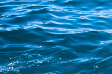 small blue sea waves form a pattern.