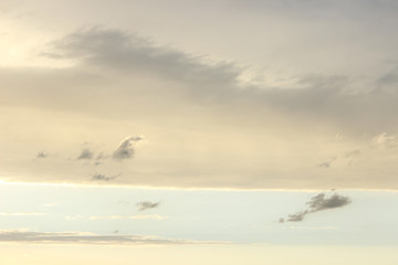 Grey yellow clouds on pale blue sky after rain