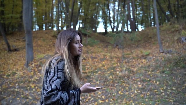 girl walking in the park and use mobile phone texting