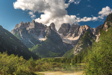 Fototapeta na wymiar Lake in a beautiful park and mountains, Dolomites in Italy, south tyrol.